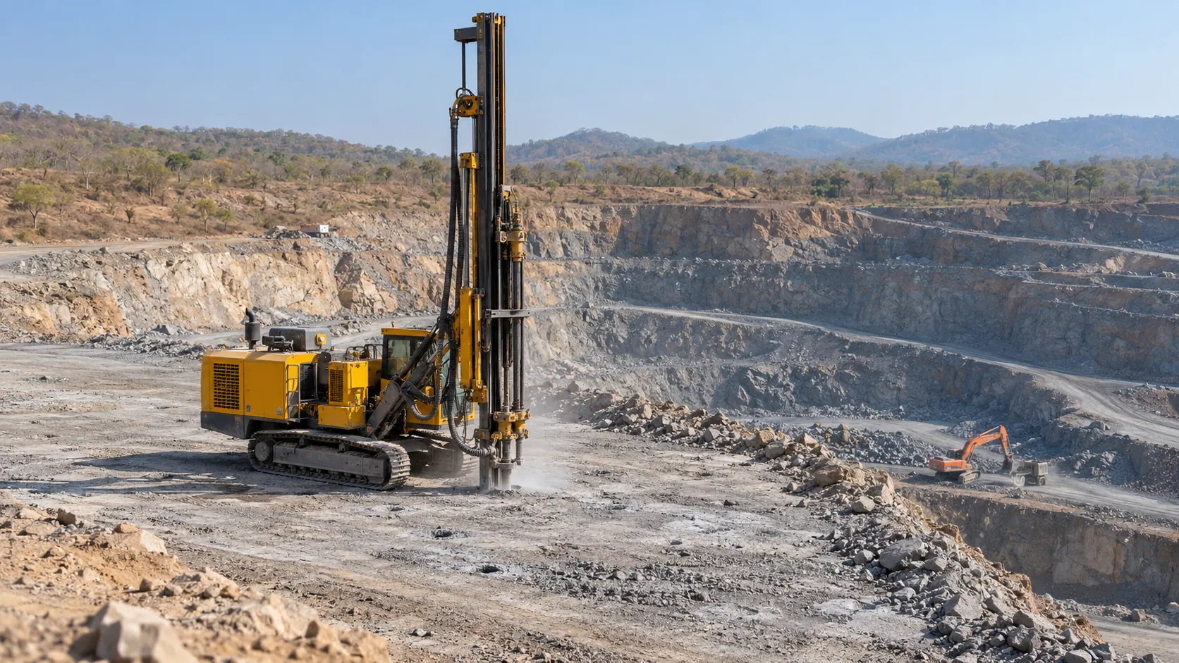 Crawler drill rig on the quarry floor, with worked benches stretching behind it